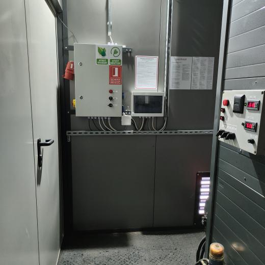 Wnętrze mobilnej kotłowni kontenerowej na wynajem od Plomex-Pol z widocznym panelem sterowania, automatyką i szafą elektryczną instalacji grzewczej na olej opałowy.