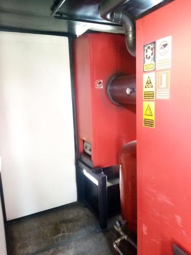 Wnętrze mobilnej kotłowni kontenerowej Plomex-Pol MAC-170kW z widocznym kotłem, naczyniem przeponowym i multicyklonem spalin.