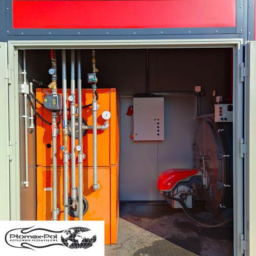 Wnętrze mobilnej kotłowni kontenerowej 600 kW marki Płomex-Pol. Widać zamontowany w kotle CO palnik na olej opałowy, zbiorniki CWU i instalację hydrauliczną z pompami obiegowymi oraz szafę sterowniczą.
