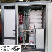 Wnętrze mobilnej kotłowni kontenerowej 200kW firmy Płomex-Pol do wynajmu. Widoczny kocioł Viessmann, biały zbiornik na olej opałowy, naczynie wzbiorcze, pompy i instalacja rurowa.