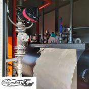 Wnętrze mobilnej kotłowni kontenerowej 600 kW na olej opałowy z widoczną pompą Grundfos. Kotłownia marki Płomex-Pol.