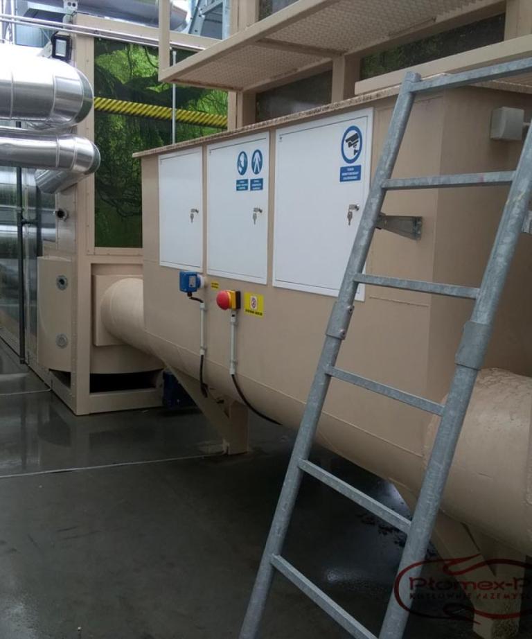 Instalacja techniczna kotłowni kontenerowej na biomasę: szczegółowy widok systemu podawania paliwa.