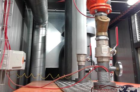 Wnętrze mobilnej kotłowni kontenerowej na pellet w Pile – widok na instalację z rurami, zaworami i systemem glikolowym.