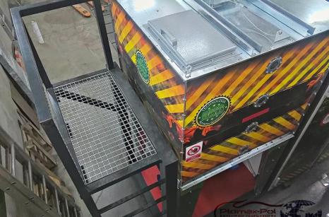 Metalowy podest roboczy z drabinką przymocowany do kontenerowej kotłowni mini 100 kW firmy Plomex-Pol