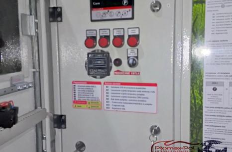 Panel sterowania mini-kotłowni kontenerowej 100 kW Plomex-Pol z cyfrowym licznikiem czasu pracy, przyciskami alarmowymi i instrukcją obsługi.